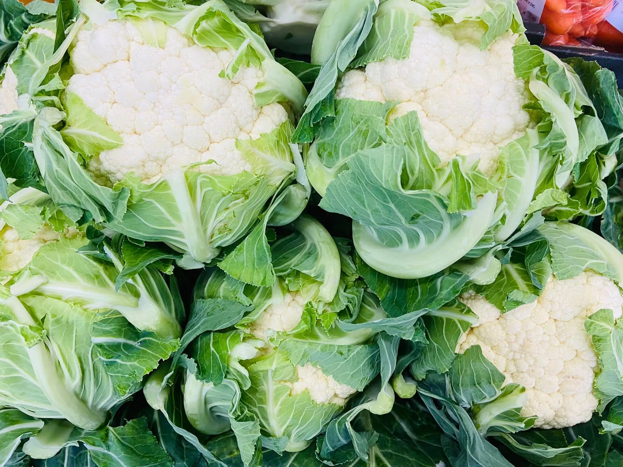 Whole cauliflower heads with leaves on