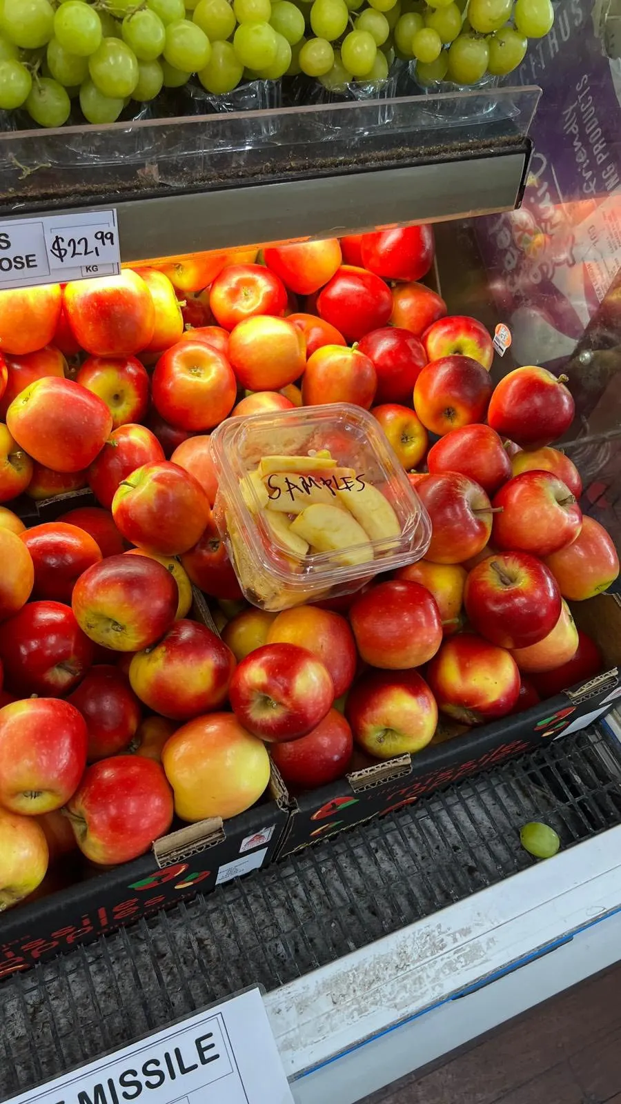 Green grapes and red apples stacked on the display